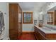 Bathroom with double sinks, shuttered windows, and dark wood cabinets at 7088 Indian Peaks Trl, Boulder, CO 80301