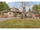Beautifully landscaped home featuring a tan exterior, a paved driveway, and mature trees at 7088 Indian Peaks Trl, Boulder, CO 80301