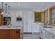 Bright kitchen with white cabinetry, stainless steel appliances, and marble countertops at 7088 Indian Peaks Trl, Boulder, CO 80301