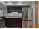 Modern wet bar with dark cabinets, stainless steel appliances, and granite counters at 7088 Indian Peaks Trl, Boulder, CO 80301