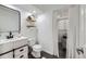 Updated bathroom featuring a white vanity, toilet, and a laundry area behind a curtain at 3801 S Joplin St, Aurora, CO 80013