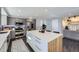 Modern kitchen features stainless steel appliances, a stylish island with bar seating, and gray cabinetry at 3801 S Joplin St, Aurora, CO 80013