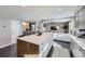 Open concept layout with a kitchen island featuring bar seating, connected to a living room at 3801 S Joplin St, Aurora, CO 80013
