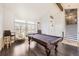 Open-concept living area featuring a pool table, vaulted ceilings, and plenty of natural light at 3801 S Joplin St, Aurora, CO 80013
