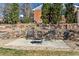 Charming backyard patio with comfortable seating around a cozy fire pit and attractive stone retaining wall at 6902 S Jackson Way, Centennial, CO 80122