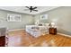 Spacious primary bedroom with hardwood floors, a ceiling fan, and large windows for natural light at 6902 S Jackson Way, Centennial, CO 80122