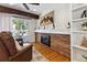 Inviting living room with brick fireplace, wood beam, and sliding door access to the outdoor patio at 6902 S Jackson Way, Centennial, CO 80122