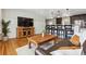 Open-concept living room featuring a seamless flow into kitchen with modern lighting and hardwood flooring at 6902 S Jackson Way, Centennial, CO 80122