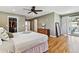 Bright main bedroom featuring a ceiling fan, hardwood floors, walk-in closet, and a sliding glass door to the outside at 6902 S Jackson Way, Centennial, CO 80122