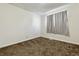 Bright bedroom with neutral walls, carpet, and a window with light-filtering curtain at 14830 Robins Dr, Denver, CO 80239