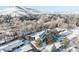 Beautiful aerial view of the snow-covered community with mature trees and mountain views in the background at 14080 Crabapple Rd, Golden, CO 80401