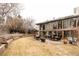 Large backyard with a mix of lawn and stone patio featuring a built-in grill and lush landscaping at 14080 Crabapple Rd, Golden, CO 80401