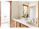 Bright bathroom with double sink, wooden vanity, and natural light, a perfect blend of style and function at 14080 Crabapple Rd, Golden, CO 80401