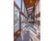 Long, sunlit hallway with stone floors, skylights, and a wrought iron spiral staircase, perfect for a modern aesthetic at 14080 Crabapple Rd, Golden, CO 80401