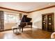 Spacious living room featuring a grand piano, large window, and classic bookshelf at 14080 Crabapple Rd, Golden, CO 80401