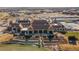 Aerial view showing the community clubhouse with terraced landscaping, tennis courts, and parking at 8240 S White Crow St, Aurora, CO 80016