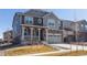 Charming two-story home featuring a covered porch, stone accents, and a two-car garage at 8240 S White Crow St, Aurora, CO 80016