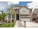 Charming two-story home featuring stone accents, a welcoming porch, and a well-manicured lawn at 8240 S White Crow St, Aurora, CO 80016