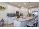 A modern kitchen is shown with white cabinetry, stainless steel appliances, and a granite countertop island with pendant lighting at 8240 S White Crow St, Aurora, CO 80016