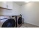 Laundry room featuring modern, front-loading washer and dryer and built-in cabinets at 8240 S White Crow St, Aurora, CO 80016