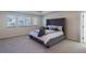 A main bedroom with gray upholstered bed and three windows allowing natural light to enter the room at 8240 S White Crow St, Aurora, CO 80016