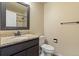 Bathroom with dark vanity, granite counter, modern faucet and matching mirror at 1065 Cobblestone Dr, Highlands Ranch, CO 80126