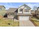 Charming two-story home featuring a manicured lawn, front porch, and an attached two-car garage at 1065 Cobblestone Dr, Highlands Ranch, CO 80126