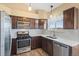 Well-lit kitchen with stainless steel appliances, wood floors, and white stone countertops at 1065 Cobblestone Dr, Highlands Ranch, CO 80126