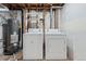 Bright laundry room with washer, dryer, water heater, and storage shelves at 1065 Cobblestone Dr, Highlands Ranch, CO 80126