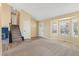 Open-concept living room showcasing natural light, plush carpeting, and staircase at 1065 Cobblestone Dr, Highlands Ranch, CO 80126