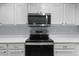 Close up of range and microwave in the kitchen with sleek white cabinets and modern appliances at 12711 Colorado Blvd # 1116, Thornton, CO 80241