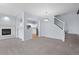 Open-concept living room with fireplace, kitchen view, and carpeted stairs to the upper level at 12711 Colorado Blvd # 1116, Thornton, CO 80241