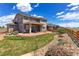 Spacious backyard with a stone patio, lush grass, and meticulous landscaping at 4220 Kestrel Dr, Broomfield, CO 80023