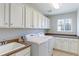 Well-equipped laundry room with white appliances, ample storage, and neutral countertops at 4220 Kestrel Dr, Broomfield, CO 80023