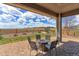 Covered patio with a stone fire pit and seating, overlooking a lush, open backyard at 4220 Kestrel Dr, Broomfield, CO 80023
