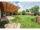Backyard featuring a covered patio with string lights and lush landscaping at 8525 Grandview Ave, Arvada, CO 80002