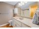 Clean bathroom with an extended vanity, decorative mirror and a glimpse into the shower at 8525 Grandview Ave, Arvada, CO 80002
