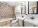 Bathroom showcasing decorative tile, a shower and tub, and double sinks with vanities at 8525 Grandview Ave, Arvada, CO 80002
