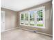 Neutral bedroom featuring carpet, large windows, and a door to another area at 8525 Grandview Ave, Arvada, CO 80002