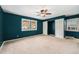 Bedroom with dark teal walls, two windows letting in natural light, and built-in storage at 8525 Grandview Ave, Arvada, CO 80002