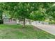 A well-maintained home features mature shade trees, a tidy lawn, and a spacious driveway at 8525 Grandview Ave, Arvada, CO 80002