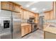 Kitchen featuring wood cabinets, stainless steel appliances, granite countertops, and tile flooring at 8525 Grandview Ave, Arvada, CO 80002