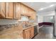 Kitchen featuring wood cabinets, stainless steel appliances, and granite countertops at 8525 Grandview Ave, Arvada, CO 80002
