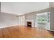 Spacious living room featuring gleaming hardwood floors, a charming fireplace, and abundant natural light at 8525 Grandview Ave, Arvada, CO 80002