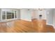 Open living area with polished wood floors, large windows, and an open flow to the dining area at 8525 Grandview Ave, Arvada, CO 80002