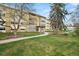 Inviting apartment building with well-maintained landscaping and mature trees against a blue sky backdrop at 720 S Clinton St # 1B, Denver, CO 80247