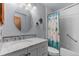 Charming bathroom features white vanity with marble countertop and shower with blue curtain at 13341 Birch Cir, Thornton, CO 80241
