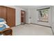 Bright bedroom with large window and closet; an open doorway leads to the stairway at 13341 Birch Cir, Thornton, CO 80241