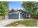Charming blue two-story home featuring a two-car garage and lush front yard at 13341 Birch Cir, Thornton, CO 80241