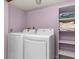 Convenient laundry area with modern washer, dryer, and storage shelving at 13341 Birch Cir, Thornton, CO 80241